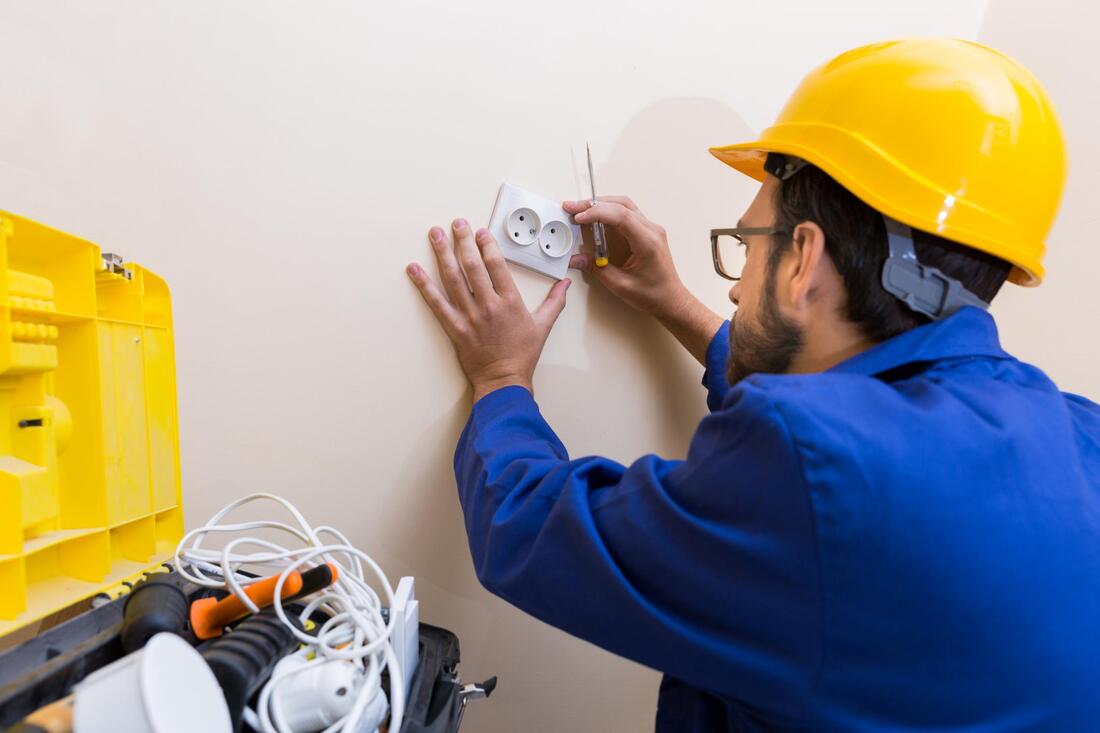 man installing electrical socket