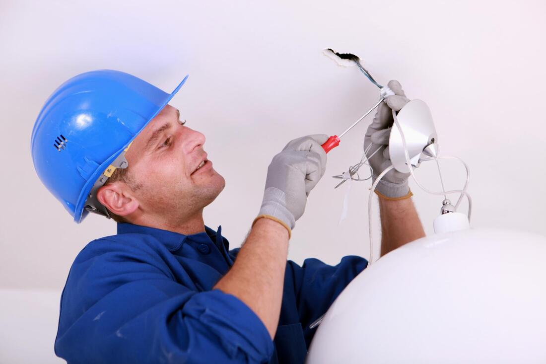 man installing chandelier lights